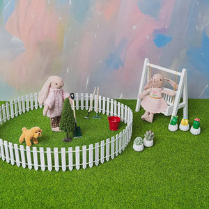 Clara the bunny standing by a miniature white picket fence, part of the 1:12 dollhouse garden set.