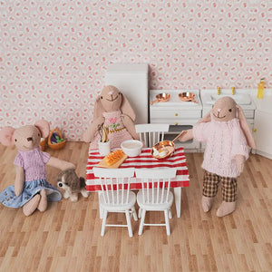 Mouse, bunny and bunny mom gathered around a miniature dining table with baking items in a warm kitchen scene