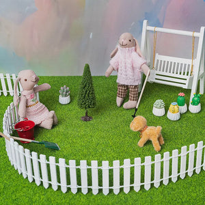 Bunny figurine sitting on a white miniature garden swing, part of the 1:12 story box collection.