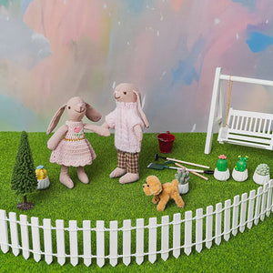 Close-up of miniature gardening tools and watering can used for planting the tiny sapling tree.