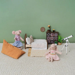 Detailed dollhouse furniture set with a carved wooden bed, bohemian cabinet, and rug.