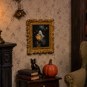 Gold ghost portrait displayed above books, a black cat and pumpkin in a cozy gothic dollhouse corner