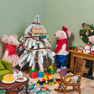 Festive mouse dad beside a snowy Christmas tree and colorful presents, sharing a joyful holiday moment with his family.