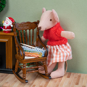 Handmade mouse doll beside a wooden rocking chair with tiny knitting, creating a heartwarming Christmas living room scene.