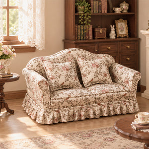 Floral two-seater sofa styled with a bookcase, side table and tea set in a warm vintage miniature interior
