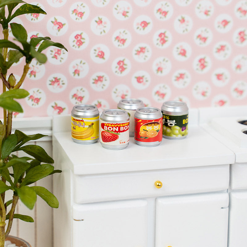 Colorful miniature drink cans styled on dollhouse countertop, cheerful soda decor for kitchen snack corner with cozy everyday realism