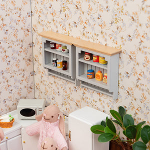 Whimsical dollhouse kitchen scene with gray wall cabinets, displaying jams and coffee for cozy countertop storytelling.