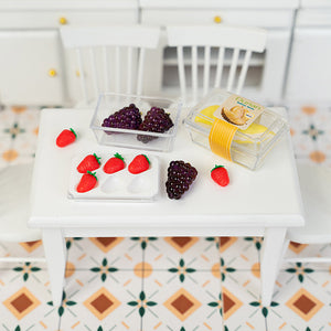 Assorted miniature fruit boxes displayed on dining table, dollhouse grocery shopping scene with strawberries, grapes, and durian in cozy home style