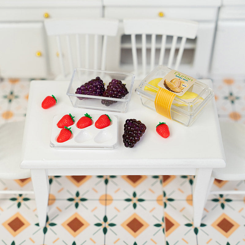 Assorted miniature fruit boxes displayed on dining table, dollhouse grocery shopping scene with strawberries, grapes, and durian in cozy home style