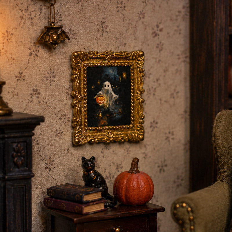 Gold ghost portrait displayed above books, a black cat and pumpkin in a cozy gothic dollhouse corner