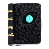 Miniature dragon eye spell book with turquoise eye, textured black cover and gold-tone spine details