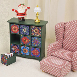 Green miniature storage cabinet styled beside a cozy armchair, adding colorful character to a tiny living room