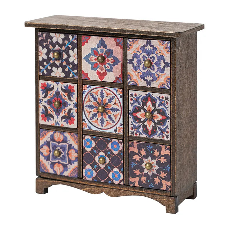 Dollhouse cabinet in warm brown wood with bohemian patterned drawers, adding vintage warmth to a cozy miniature room