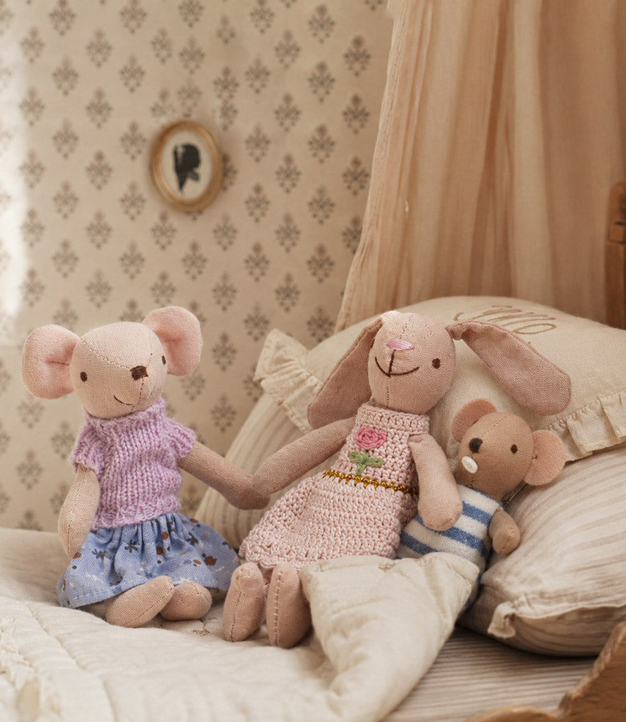 Cozy dollhouse nursery with bunny and mouse family tucked into soft bedding for a warm bedtime story scene