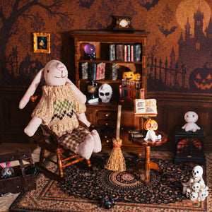 Bunny figure enjoys a cozy Halloween study with rocking chair, fireplace, spell books and tiny spooky guests