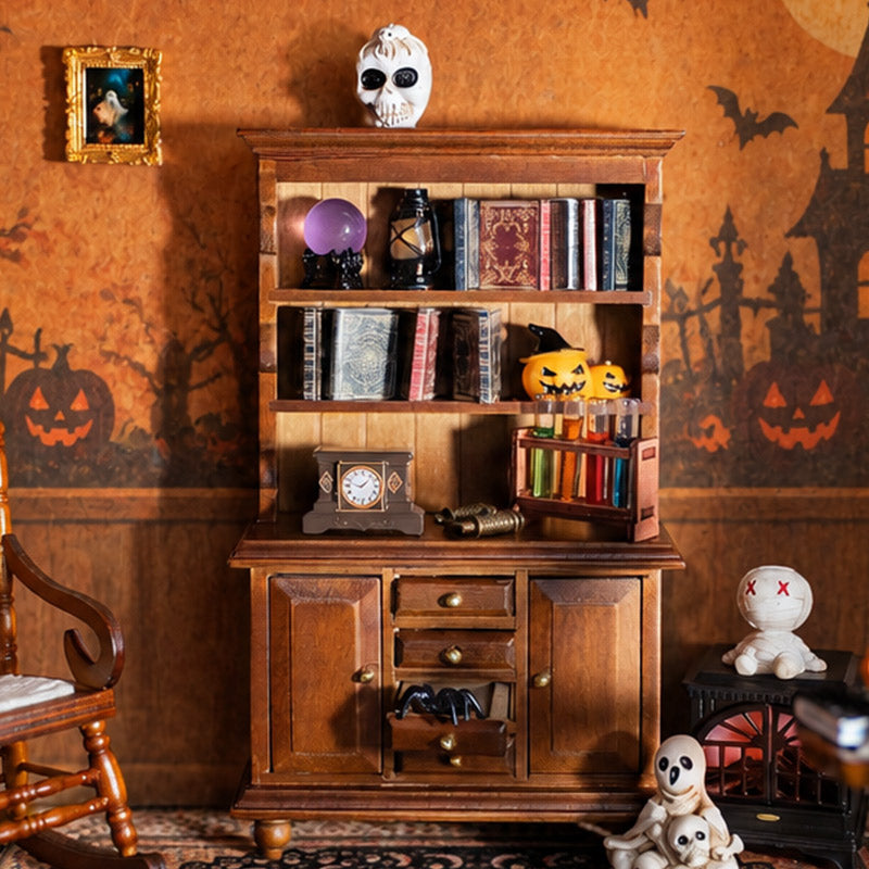 Vintage dollhouse hutch styled with spell books, crystal ball, pumpkins and tiny Halloween decorations