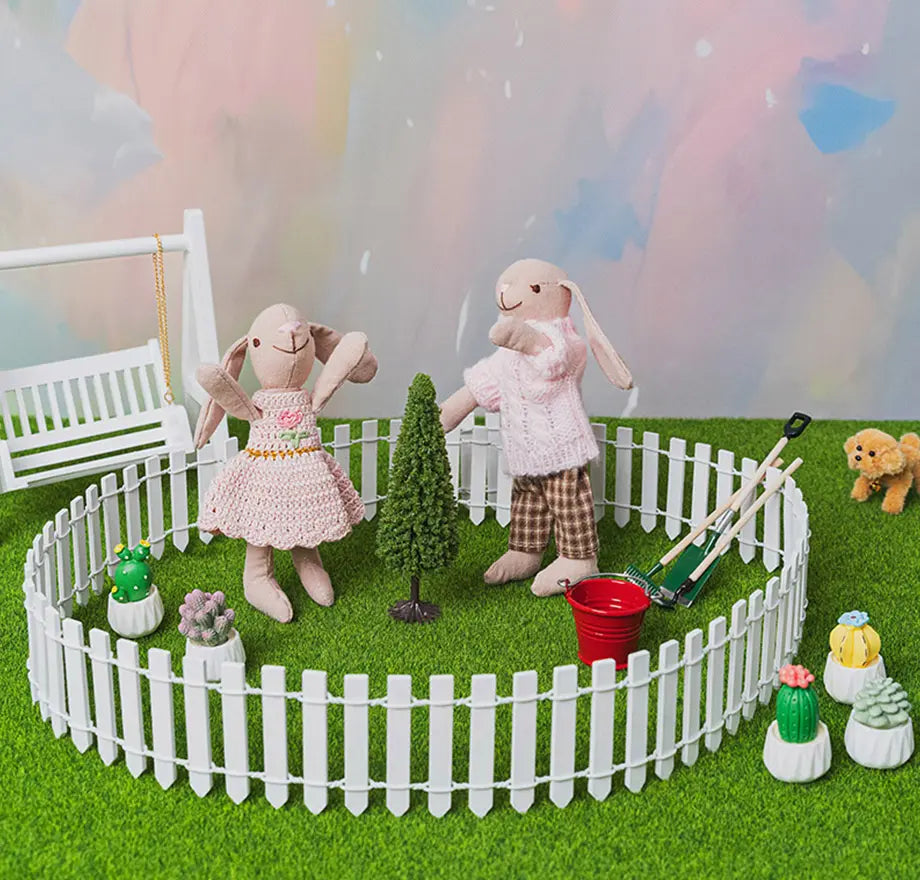 Spring garden storytelling scene with miniature yard decor, featuring a white picket fence, garden swing, tiny tree, and cozy outdoor accessories for 1:12 scale dollhouse play
