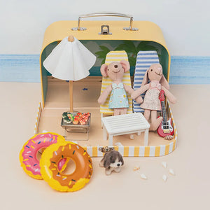Miniature beach scene inside a portable dollhouse case with tiny furniture, creating a sunny seaside story world