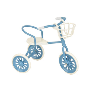 Blue dollhouse tricycle with basket, a cheerful miniature ride for garden paths and playful everyday adventures