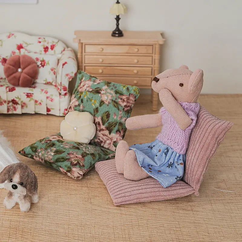 Dollhouse floor sofa with floral cushions creating a warm reading nook and playful home scene