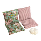Dollhouse floor sofa with vintage floral fabric and white pillow, creating a cozy miniature sitting space