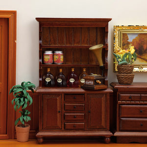 Chestnut wooden cabinet styled with bottles, plants and a gramophone for a cozy vintage living room display