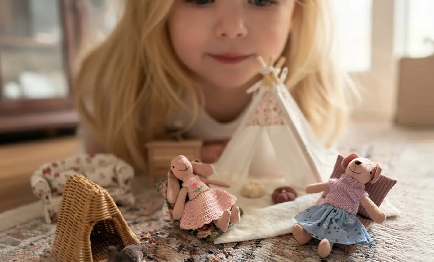 Girl playing with Kivvi Tales 1:12 scale dollhouse miniatures in a cozy story scene
