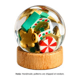 Miniature Christmas Snow Globe with colorful candy decorations and a wooden base, adding festive charm to holiday decor