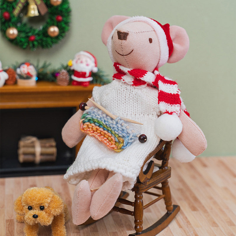Colorful miniature knitting resting on a rocking chair beside a cozy fireplace, capturing a peaceful holiday afternoon.